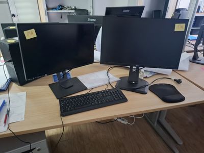 two computer monitors and a keyboard on a desk