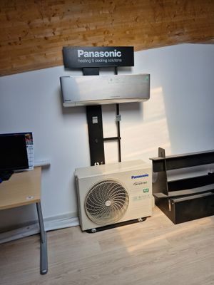 une photo d'une pièce avec un bureau et un climatiseur