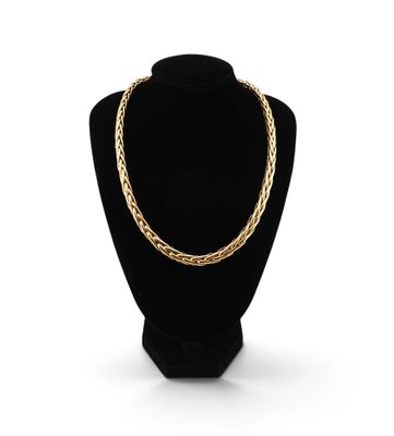 un collier à chaîne en or sur un présentoir à mannequin