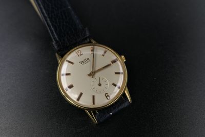 a close up of a watch on a black surface