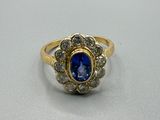gros plan d'une bague en or avec une pierre bleue