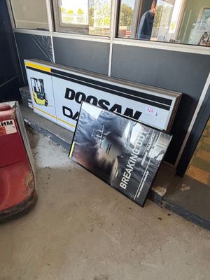 un panneau posé par terre devant un bâtiment