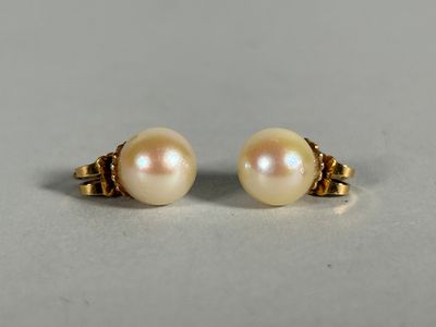 a pair of pearl earrings on a white surface