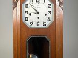 une horloge en bois dans laquelle se trouve un chat noir