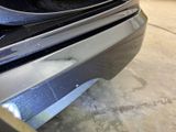 a close up of a car ' s front bumper with a cat on it