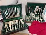 deux sets d'argenterie dans un coffret sur une table