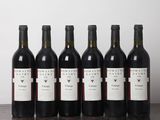 six bouteilles de vin sont alignées sur une table en bois