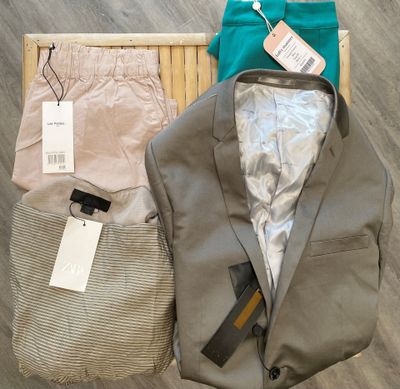 a suit jacket, pants, and a bag on the floor