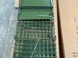 une cage verte avec un oiseau à l'intérieur, posée sur une boîte