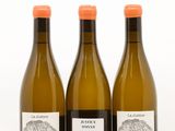 trois bouteilles de vin posées les unes à côté des autres sur une surface blanche