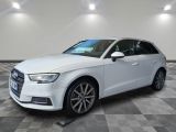 Une Audi blanche est garée sur un sol en carrelage à damier.