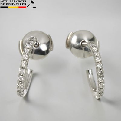 une paire de boucles d'oreilles créoles en diamant sur fond blanc