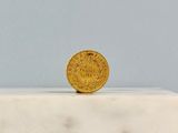 a gold coin sitting on top of a marble block