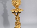 an image of a gold candle holder with a bird on it