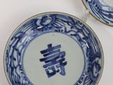 two blue and white plates with chinese writing on them