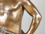 bronze statue of a man holding a fish in his right hand