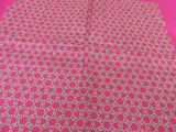pink and gold table cloth with a pattern of circles on a pink background
