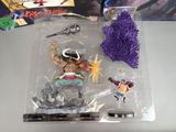 a plastic figure of a man with a sword and a purple brush