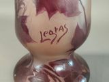 a glass vase with a leaf design on it