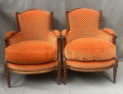 une paire de fauteuils rembourrés orange sur fond gris