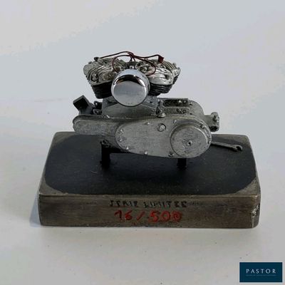 une sculpture métallique représentant une moto posée sur un livre