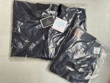 deux sacs de vêtements posés par terre l'un à côté de l'autre