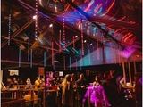 many people that are standing under a tent at a party