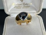 a gold ring with a blue stone inside of it