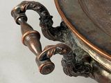 a metal bowl with a handle on a white table