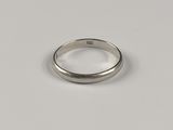 gros plan d'une bague en argent sur une surface blanche