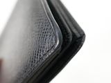 a person holding a black leather wallet in their hand
