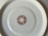 a white plate with a red stamp on it sitting on a table