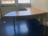 un bureau dans un coin d'une pièce, avec une fenêtre en arrière-plan