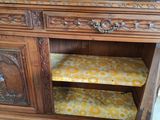 an old wooden cabinet with a yellow cushion on top of it