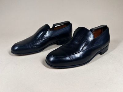 a pair of men ' s black leather shoes on a white surface
