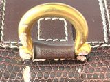brown leather purse with a gold ring on top of it