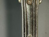 a close up of a silver spoon with a clock on it
