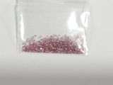 a small bag of pink glitter on a white surface