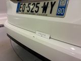 the rear end of a white car with a license plate on it
