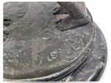 a bronze statue of a boy standing on a pedestal