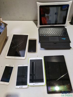 a laptop, tablet, phone, and other electronic devices sitting on a table