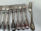 a lot of silver forks and spoons on the table