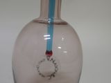a pink glass bottle with a blue handle and a yellow handle