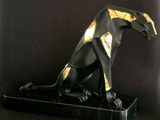 statue of a black and gold cat sitting on a black marble base