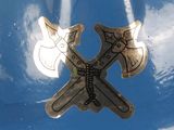 a close up of a metal object with two crossed axes on it