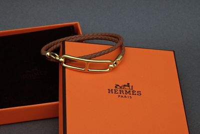 an orange box with a brown leather bracelet inside of it