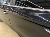 a black car parked in a garage with its door open