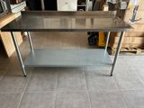 une table en acier inoxydable au milieu d'une pièce