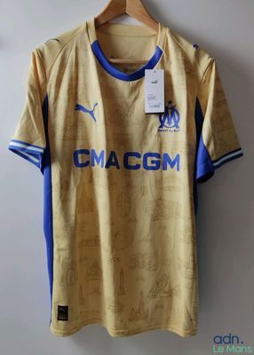un maillot de foot jaune et bleu suspendu à un cintre