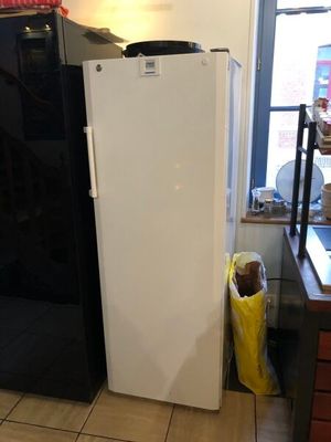 a white refrigerator in a kitchen next to a window